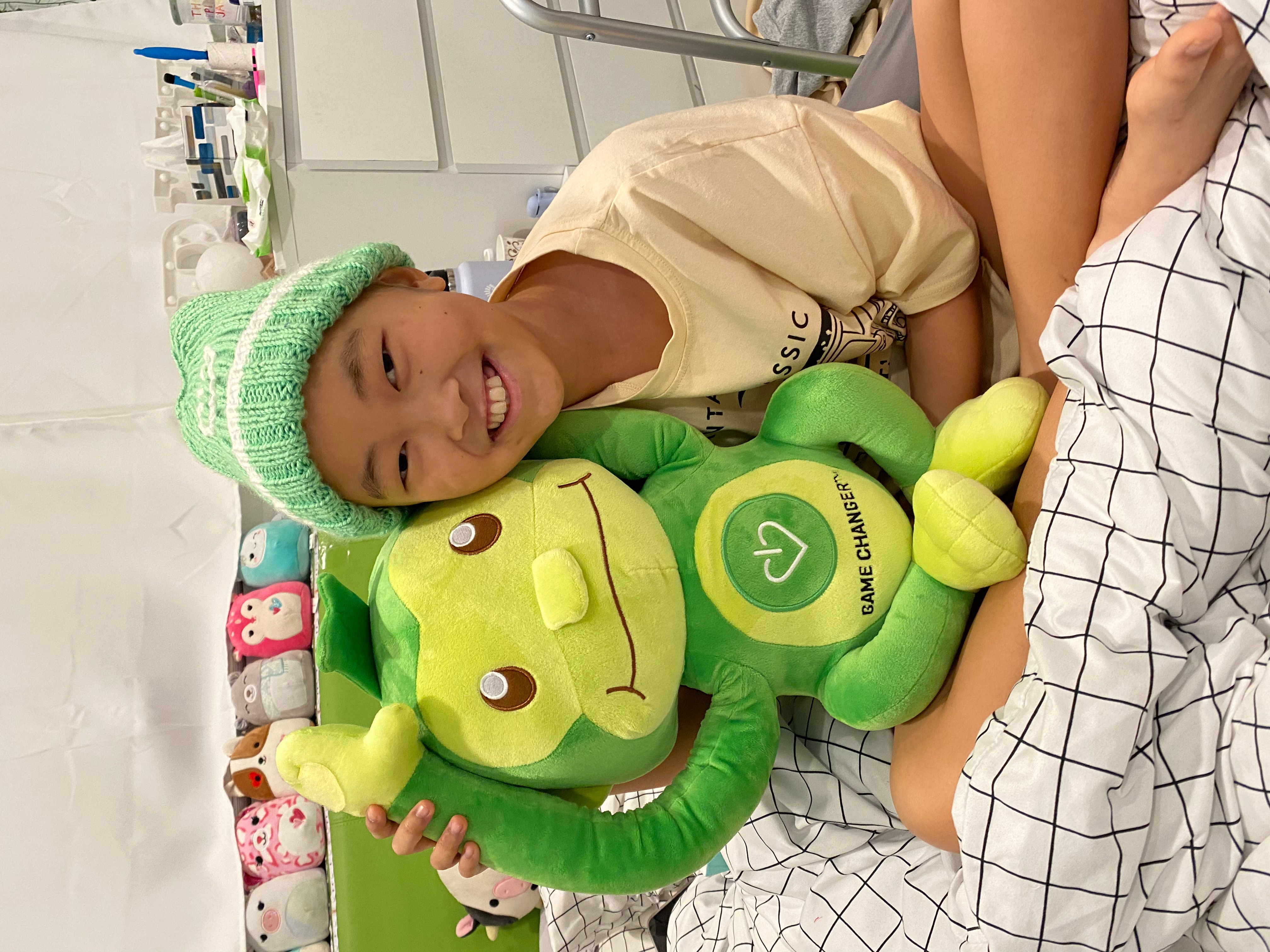 A young patient holding Hope, the green monkey.